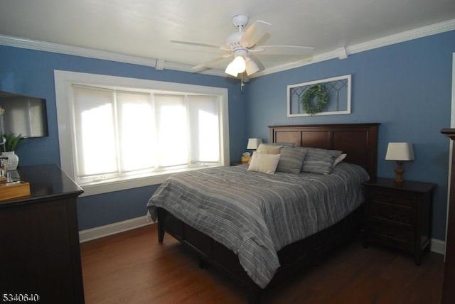 bedroom featuring dark wood-style floors, ornamental molding, a ceiling fan, and baseboards