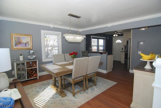 dining space featuring ornamental molding, a wealth of natural light, visible vents, and wood finished floors