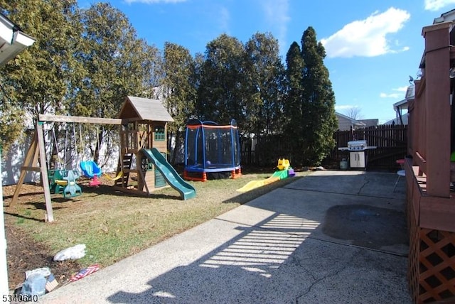 view of play area with a patio, a trampoline, fence, and a lawn