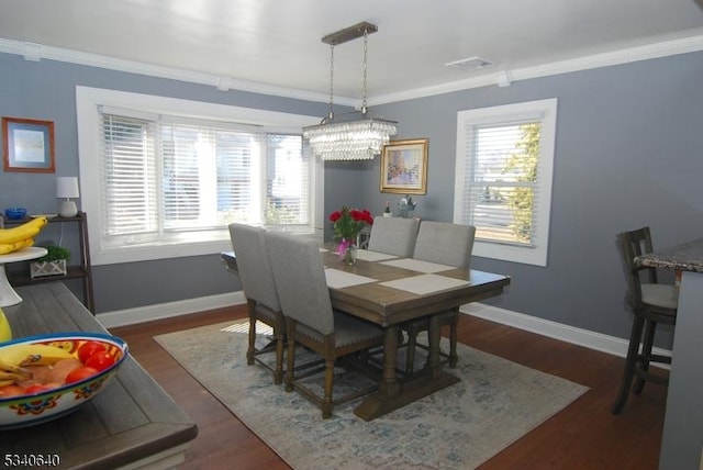 dining space with a wealth of natural light, crown molding, and baseboards