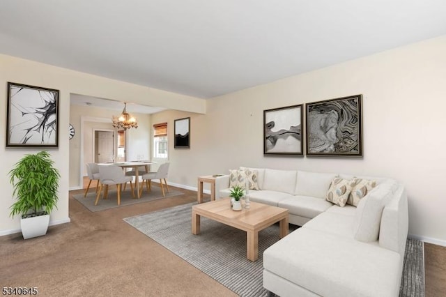 carpeted living area featuring an inviting chandelier and baseboards