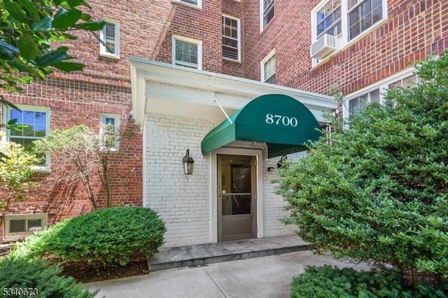 view of exterior entry with brick siding