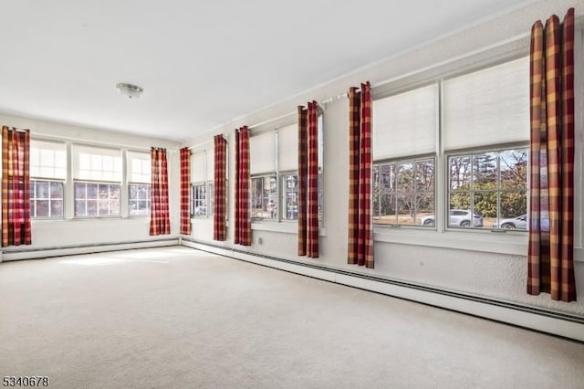 carpeted empty room with a baseboard heating unit