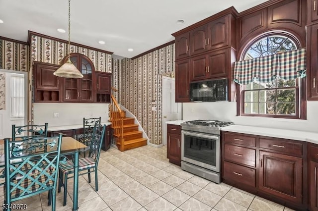 kitchen with black microwave, light countertops, stainless steel gas range, and wallpapered walls