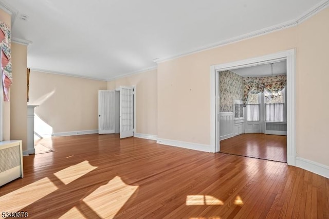 unfurnished living room with baseboards, a fireplace, ornamental molding, and hardwood / wood-style floors