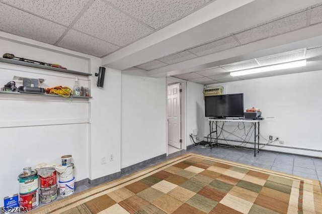 finished basement with a paneled ceiling and baseboard heating