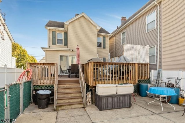 rear view of house featuring fence and a wooden deck