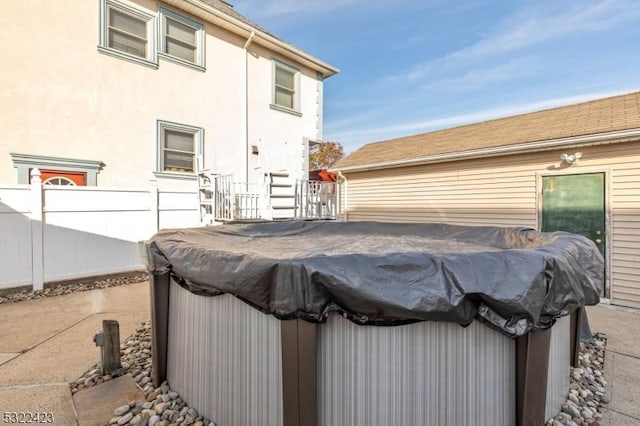 view of patio / terrace featuring fence and a hot tub