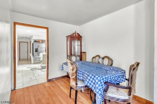 dining room with light wood-type flooring and baseboards