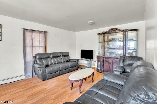 living area featuring a baseboard heating unit and wood finished floors