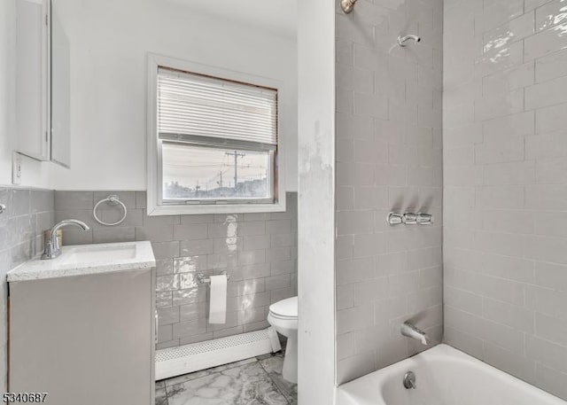 full bathroom featuring wainscoting, toilet, bathtub / shower combination, vanity, and tile walls