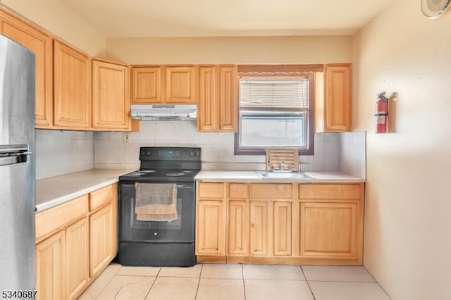 kitchen with black / electric stove, under cabinet range hood, light countertops, backsplash, and light brown cabinetry