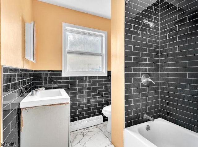 full bath featuring toilet, vanity, marble finish floor, shower / bathtub combination, and tile walls