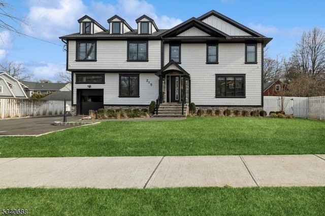 view of front of house with a garage, driveway, a front yard, and fence