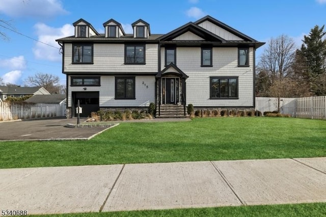 view of front of home with a garage, fence, aphalt driveway, and a front yard