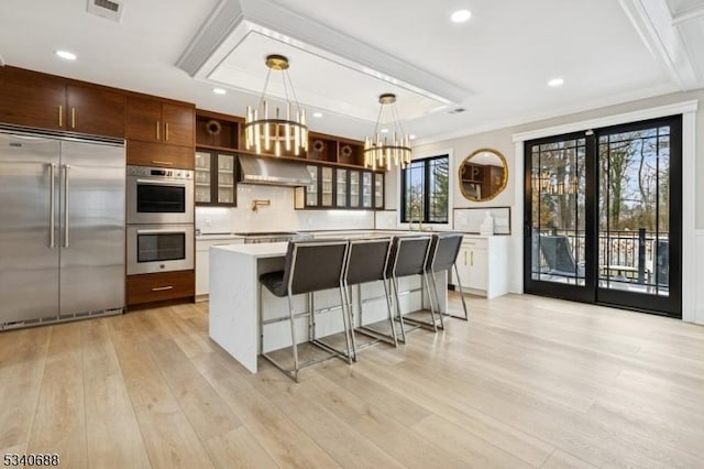 kitchen with open shelves, stainless steel appliances, light countertops, visible vents, and light wood-style flooring