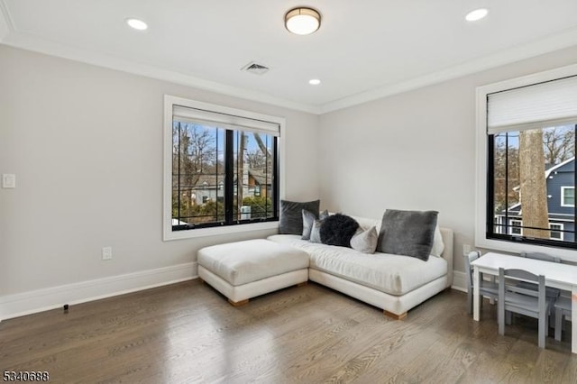 sitting room with ornamental molding, wood finished floors, a wealth of natural light, and baseboards