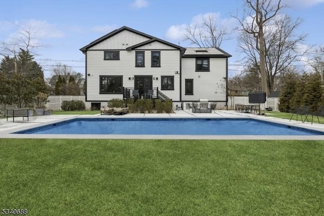 back of property with fence, an outdoor pool, a lawn, and a patio