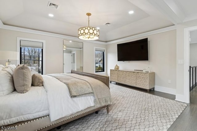 bedroom featuring crown molding, a raised ceiling, visible vents, wood finished floors, and baseboards