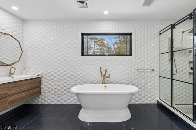 bathroom with vanity, visible vents, a freestanding bath, tiled shower, and tile patterned floors