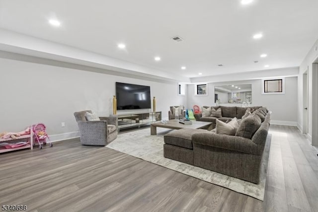 living area featuring light wood-style floors, recessed lighting, visible vents, and baseboards