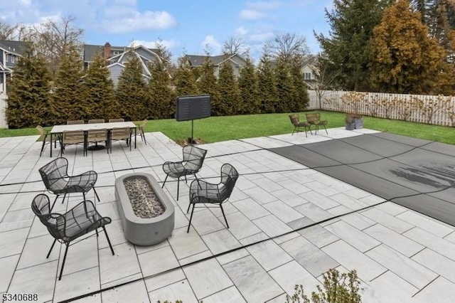 view of patio / terrace featuring outdoor dining space, fence, and a fire pit