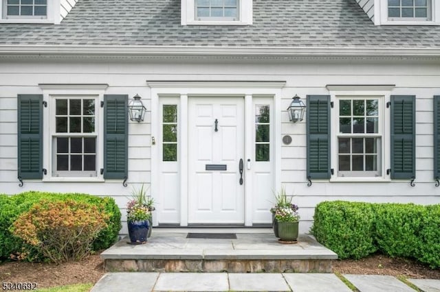 doorway to property featuring a shingled roof