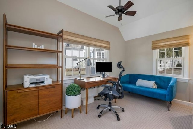 office area featuring light colored carpet, vaulted ceiling, baseboards, and ceiling fan