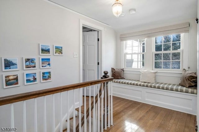 corridor featuring light wood finished floors and an upstairs landing