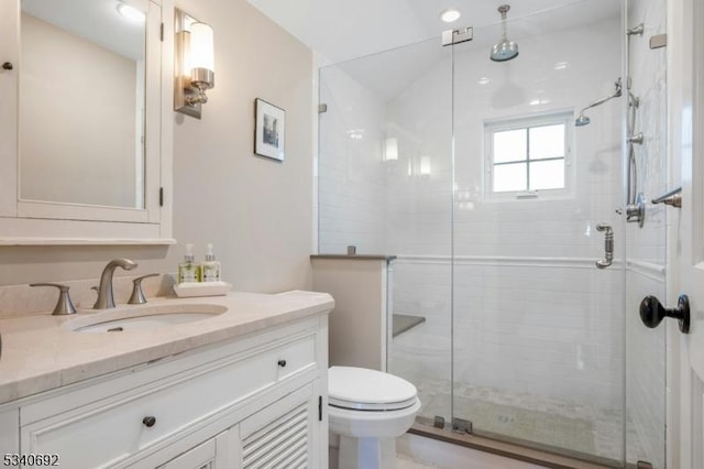 full bathroom featuring a stall shower, vanity, and toilet