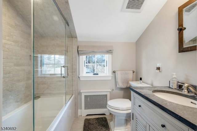 full bath featuring radiator, toilet, enclosed tub / shower combo, vaulted ceiling, and vanity