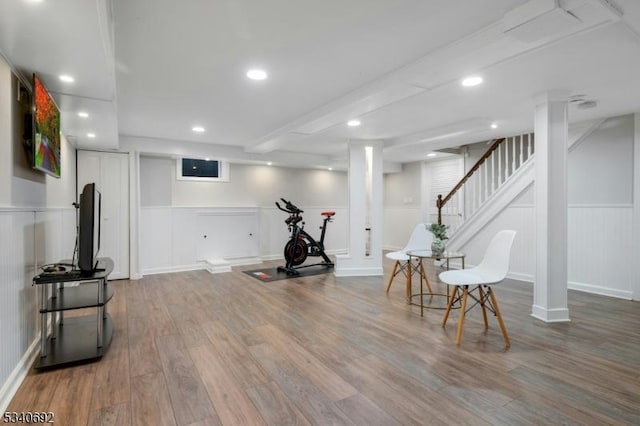 workout area with a decorative wall, wainscoting, wood finished floors, and recessed lighting