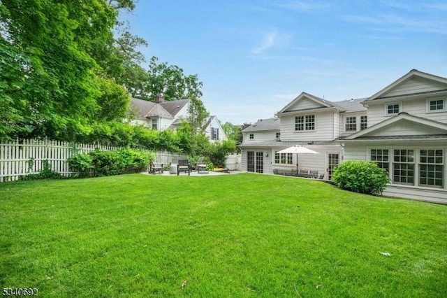 back of property featuring a yard, a patio, and fence