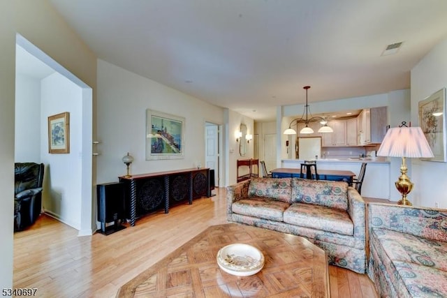 living area with visible vents and light wood-style floors