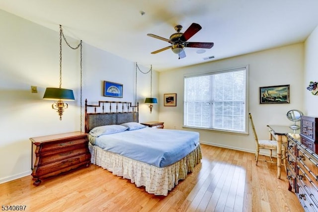 bedroom featuring visible vents, baseboards, and wood finished floors