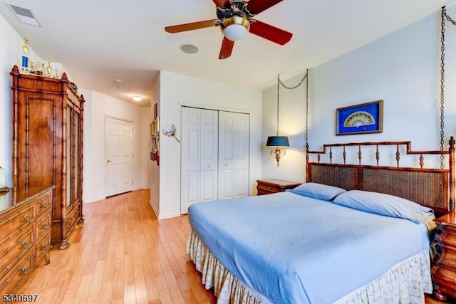 bedroom featuring a ceiling fan, a closet, visible vents, and light wood finished floors