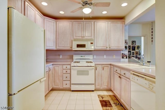 kitchen with white appliances, light countertops, a sink, and light tile patterned flooring