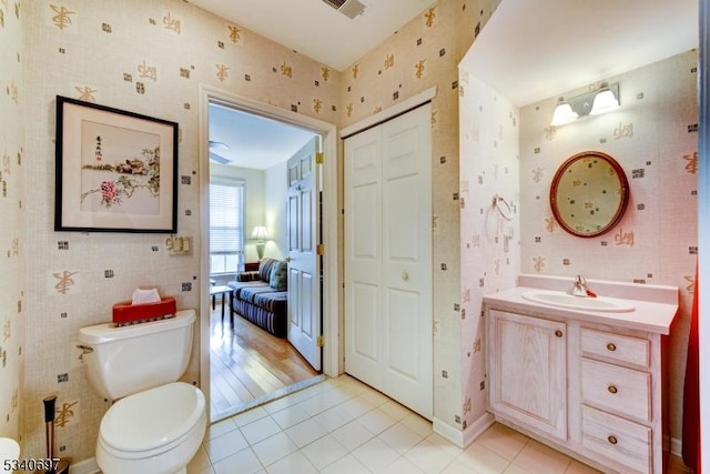 bathroom with tile patterned flooring, toilet, visible vents, vanity, and wallpapered walls