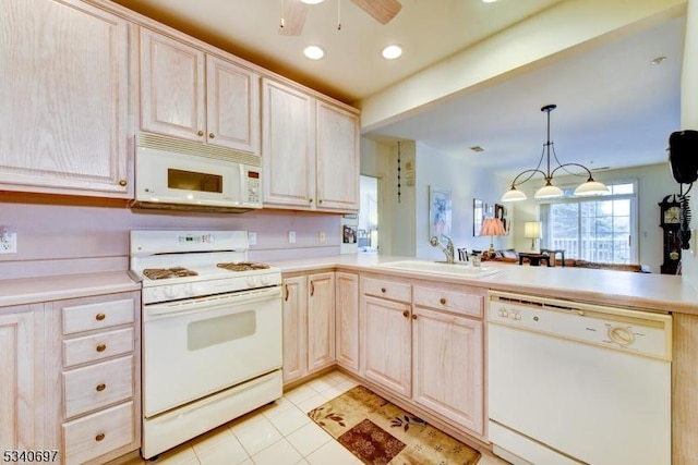 kitchen featuring ceiling fan, a peninsula, white appliances, a sink, and light countertops