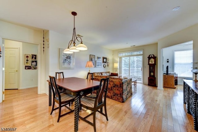 dining room featuring light wood-style flooring and baseboards