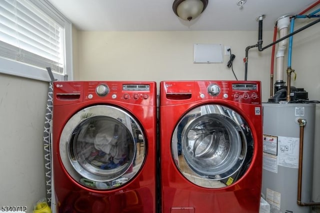 laundry room with laundry area, water heater, and independent washer and dryer