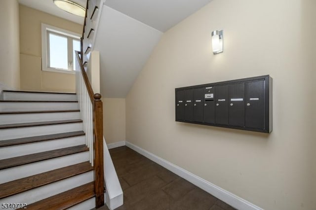 stairs featuring baseboards, vaulted ceiling, and mail area