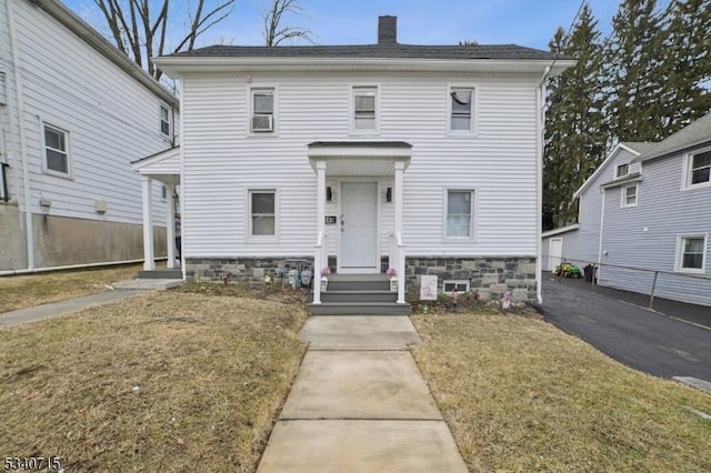 view of front of property with a chimney and a front yard