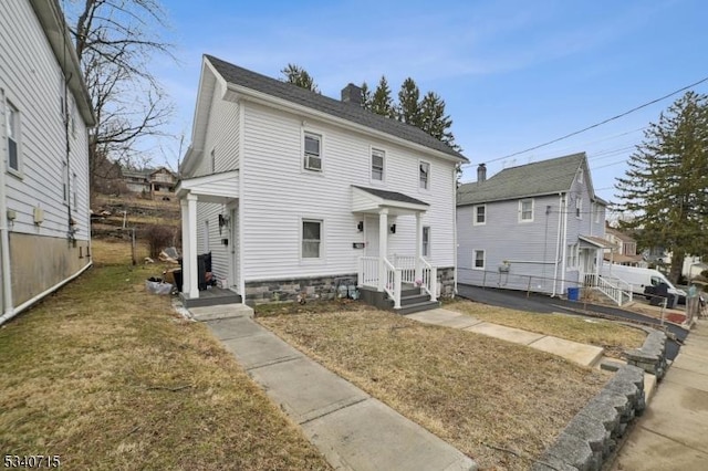 view of front of property with a chimney and a front lawn