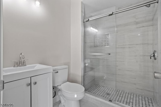 bathroom featuring a stall shower, vanity, and toilet