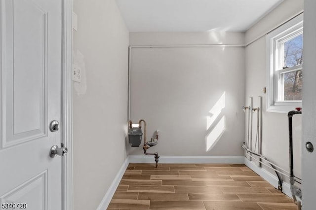 laundry room with wood finish floors and baseboards