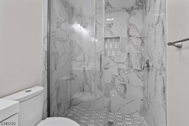 full bath with vanity, a marble finish shower, and toilet