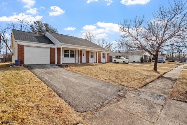 ranch-style home with brick siding, a porch, an attached garage, a front yard, and driveway