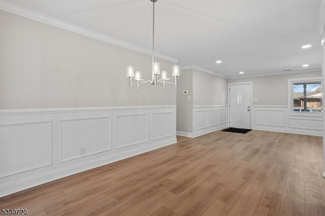 unfurnished dining area featuring a chandelier, light wood finished floors, recessed lighting, and crown molding