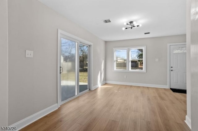 unfurnished living room featuring light wood-style floors, visible vents, and plenty of natural light